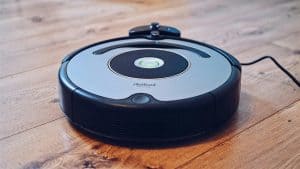 Close-up of a robotic vacuum cleaner operating on a hardwood floor, showcasing modern cleaning technology.